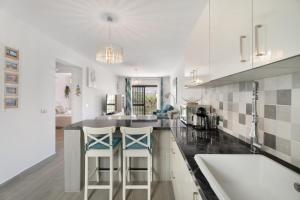 a kitchen with a counter and two bar stools at Adelfa Golf in San Miguel de Abona