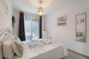 a bedroom with a bed with white sheets and a window at Adelfa Golf in San Miguel de Abona
