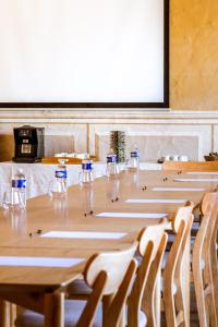 a conference room with a table with chairs and a screen at Hotel La Tramontane in Saintes-Maries-de-la-Mer