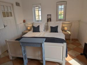 a bedroom with a large white bed with two windows at Ferienwohnung Natursjæl in Tielen