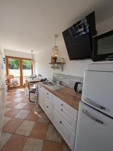 a kitchen with a white refrigerator and a table at Ferienwohnung Natursjæl in Tielen