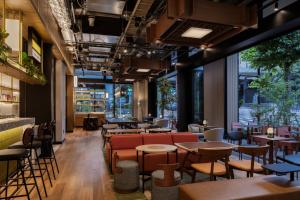 a restaurant with tables and chairs and large windows at Caption By Hyatt Kabutocho Tokyo in Tokyo