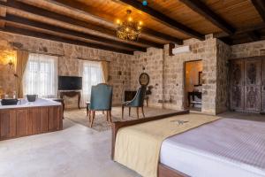 a bedroom with a bed and a desk and a television at Noble Blue Cappadocia in Ortahisar