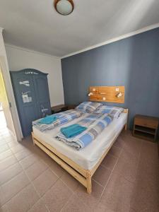 a bedroom with a large bed with blue walls at Dömös Danu Kemping in Dömös +6 photos