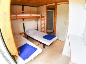 a room with two bunk beds and a hallway at Camping Onlycamp l'Astrée in Bourg-Argental