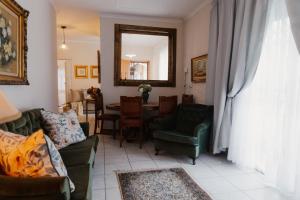 a living room with a couch and a table and a mirror at The Hidden Garden Guesthouse in Meyerton