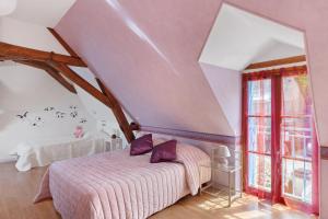 a bedroom with a bed with purple pillows at Gîte La Clématite in Mosnes