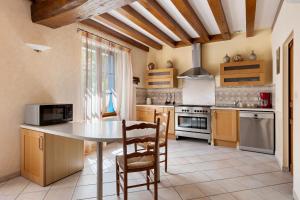 a kitchen with a table and chairs in a room at Gîte La Clématite in Mosnes