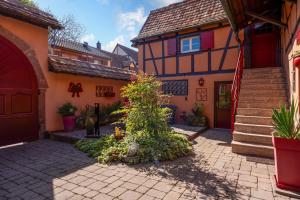 a courtyard of a house with a tree in front of it at La Cour Des Amis in Vendenheim +18 photos