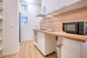 a kitchen with a counter with a microwave at L'intemporel in Périgueux