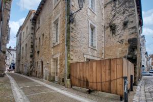an old brick building with a wooden gate on a street at L'intemporel in Périgueux