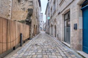 an alley way in an old city with buildings at L'intemporel in Périgueux