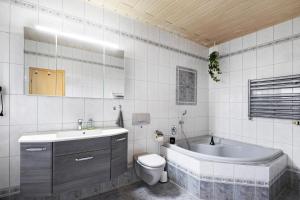a bathroom with a tub and a toilet and a sink at Familienhaus mit riesigem Garten in Arnsdorf +35 photos