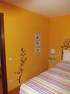 a bedroom with yellow walls and a bed at Il Vicolo in Cagli