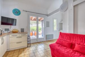 a living room with a red couch and a tv at Lacanau Océan avec jardin in Lacanau-Océan