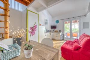 a living room with a red couch and a table at Lacanau Océan avec jardin in Lacanau-Océan