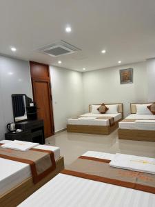 a hotel room with two beds and a television at Luxury Hotel in Tây Ninh