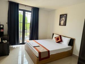 a bedroom with a bed and a large window at Luxury Hotel in Tây Ninh +1 photo