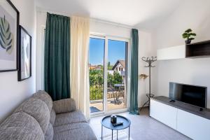 a living room with a couch and a large window at My Nest Accommodation in Privlaka