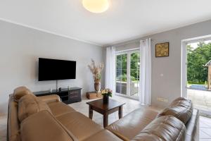 a living room with a couch and a flat screen tv at Fewo am Wasser 2 in Groß Lindow
