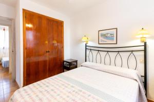 a bedroom with a bed and a wooden door at Complejo turístico Menorca SOL ISLA in Arenal d'en Castell +81 photos