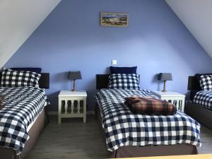 two beds in a room with blue walls at La poésie de l'instant in Bétête +20 photos
