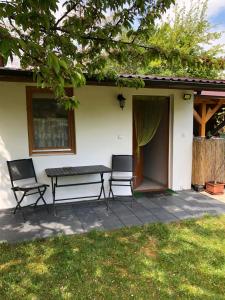 a patio with two chairs and a table in front of a house at PäRLAN APARTMAN in Balatonboglár