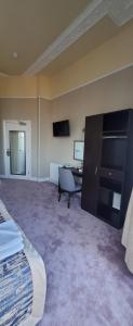 a room with a desk and a television in it at Alexandra Hotel in Eastbourne +34 photos