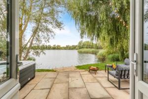a patio with a view of a lake through a window at 1 Willowmere lakeside Hideaway in Baston