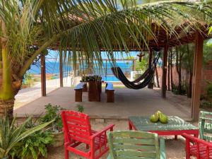 a patio with a hammock and a table and chairs at Casa Mar Alto in Icapuí
