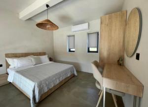 a bedroom with a bed and a table and a mirror at Villa Relax in Kallithea Halkidikis