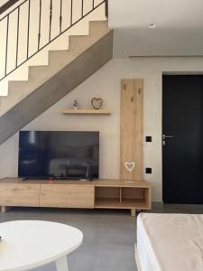 a living room with a large television and a staircase at Villa Relax in Kallithea Halkidikis