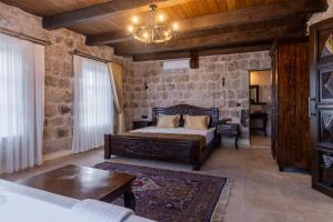 a bedroom with a bed and a stone wall at Noble Blue Cappadocia in Ortahisar +108 photos