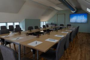 a conference room with tables and chairs and a projection screen at Hotel Libera Spa et Restaurant Caen Colombelles in Caen +108 photos