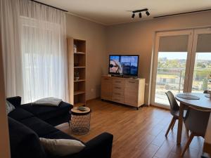 a living room with a couch and a tv and a table at Kutnowska Perła in Kutno