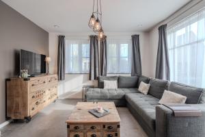 a living room with a couch and a tv at vakantiewoning T'is ier goed in Jabbeke
