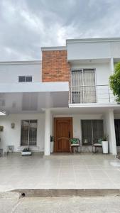 a white house with a wooden door and a patio at Casa Norte Exclusive Home-Amplia, amoblada Valledupar in Valledupar