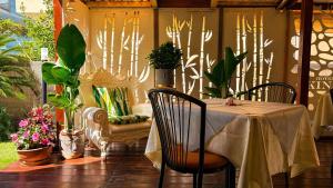 eine Veranda mit Tisch, Stühlen und Pflanzen in der Unterkunft Hotel Okinawa in Rimini