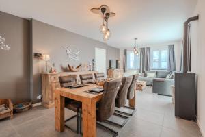 a dining room with a wooden table and chairs at vakantiewoning T'is ier goed in Jabbeke