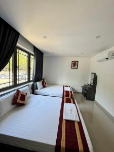 a bedroom with two beds and a window at Luxury Hotel in Tây Ninh