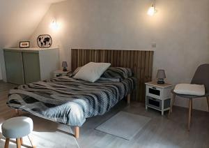 a bedroom with a bed and a table and chairs at L'Échappée en Sandales in La Gacilly