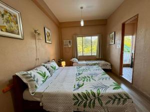 a bedroom with two beds and a window at Bananaland Cottages in Panglao Island