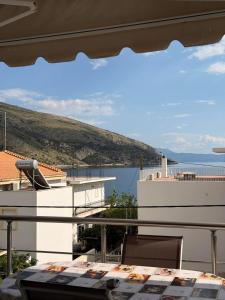 a balcony with a table and a view of the water at Pelekanos Apartment in Paralia Saranti