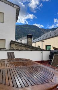 a deck with a table and chairs on a house at Biescas Suites in Biescas