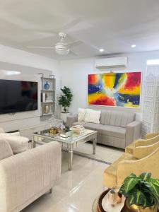 a living room with a couch and a tv at Casa Norte Exclusive Home-Amplia, amoblada Valledupar in Valledupar