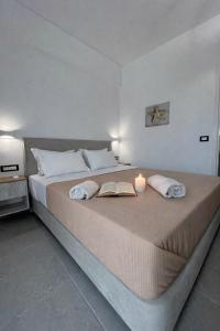 a bedroom with a large bed with a candle on it at Pension St.George Rooms & Studios in Perivolos