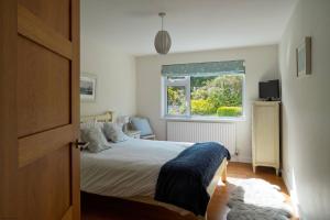 a bedroom with a bed and a window at White Sands in Croyde
