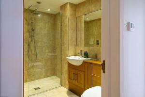 a bathroom with a shower and a sink and a toilet at White Sands in Croyde +38 photos