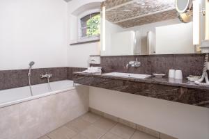 a bathroom with a bath tub and a sink at Golfpark Strelasund in Süderholz +29 photos