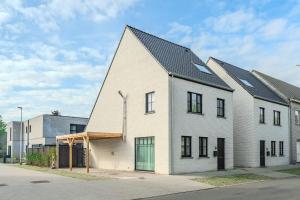 a white house with a gambrel roof at vakantiewoning T'is ier goed in Jabbeke
